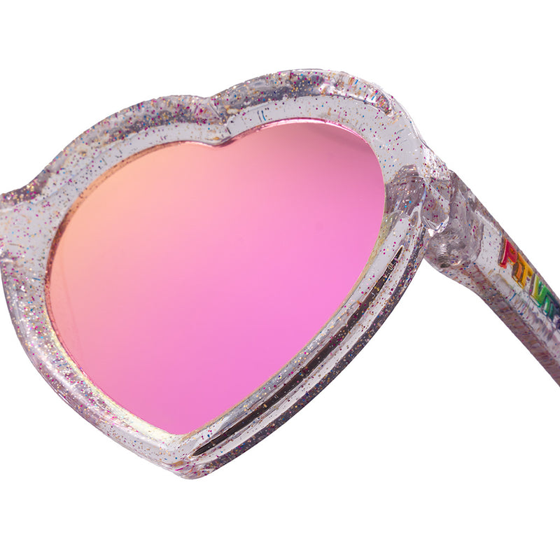 Pink | im_ready_for_my_closeup.JPG | Close-up of heart-shaped sunglasses with a glittery silver frame and a pink mirrored lens, on a white background.