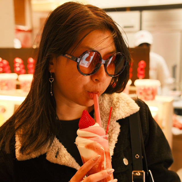 woman wearing sunglasses drinking a milkshake