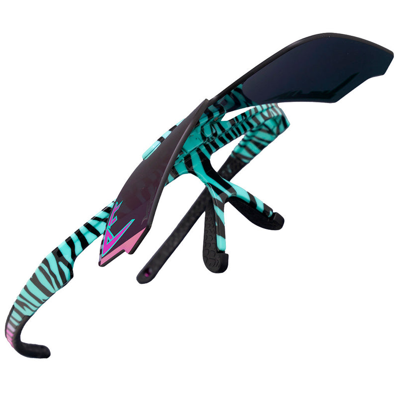 | flip_them_up.JPG | A pair of oversized shield-style sunglasses with a black and turquoise zebra-stripe pattern on the arms and bridge, a dark translucent lens, and pink accent details, shown on a plain white background.