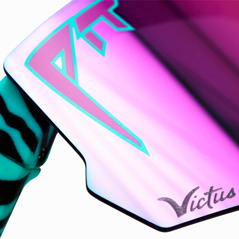 | im_ready_for_my_closeup.JPG | Close-up of a Victus sunglasses lens showing a pink and purple iridescent finish with a teal logo outline and a black-and-teal striped temple arm.