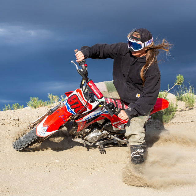 Photo of Women hitting a berm on a dirt bike wearing the Merika Brapstrap Goggles from Pit Viper